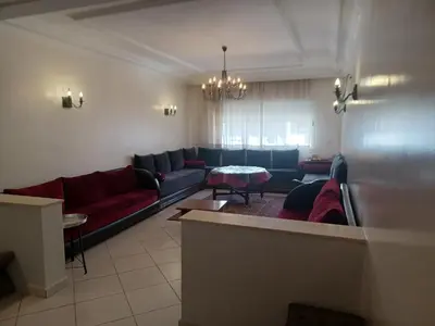 a living room with a couch and a table at Grand appartement lumineux avec balcon & parking idéal familles et pro in Casablanca