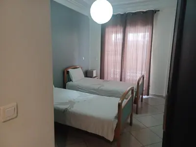 two beds in a room with a window at Grand appartement lumineux avec balcon & parking idéal familles et pro in Casablanca