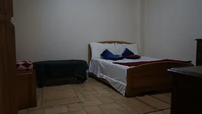 a bedroom with a bed with blue pillows on it at Auberges Des Jeunes Casablanca in Casablanca