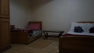 a room with two beds and a table in it at Auberges Des Jeunes Casablanca in Casablanca