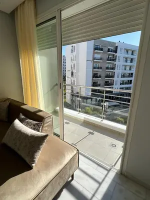 a living room with a couch and a large window at Shiny appartment in Prestigia in Rabat