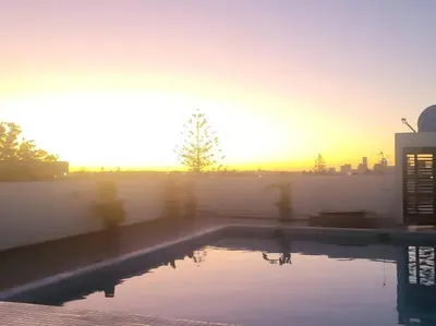 a swimming pool with the sunset in the background at Chez Miguel Casablanca in Casablanca