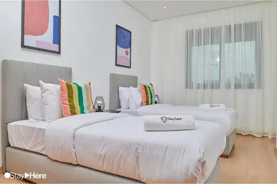 two beds in a room with white walls at Stayhere Rabat - Hay Riad - Sophisticated Residence in Rabat