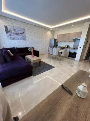 a living room with a purple couch and a kitchen at Luxurious Appartement at Casa Finance City in Casablanca