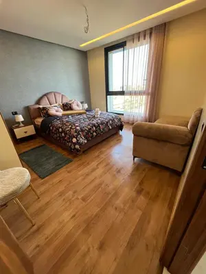 a bedroom with a bed and a couch and a chair at Luxurious Appartement at Casa Finance City in Casablanca