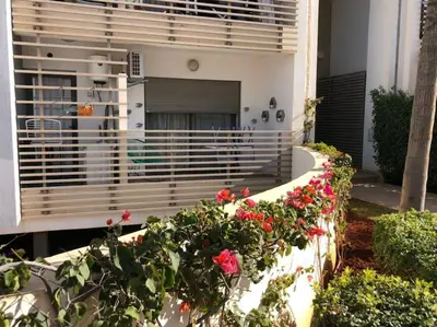 a house with a swimming pool and some flowers at Charmant studio lumineux Casablanca in Bouskoura