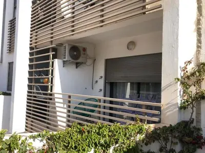 a balcony of a building with a window and a fan at Charmant studio lumineux Casablanca in Bouskoura