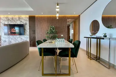 a dining room with a table and green chairs at Casablanca Marina Ocean View - By AppartAli in Casablanca