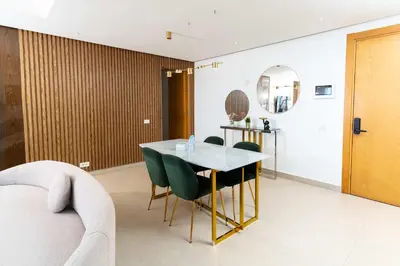 a dining room with a table and green chairs at Casablanca Marina Ocean View - By AppartAli in Casablanca