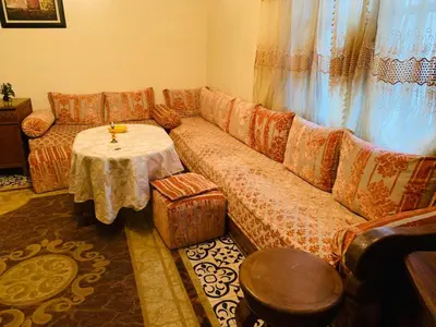 a living room with a couch and a table at Spacious bedrooms in a traditional house in Rabat