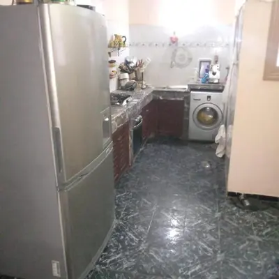 a kitchen with a stainless steel refrigerator and a washing machine at Spacious bedrooms in a traditional house in Rabat