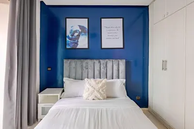 a bedroom with a blue wall with a bed at TT Holidays-Rabat City Center in Rabat