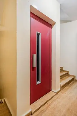 a red door in a hallway with stairs at TT Holidays-Rabat City Center in Rabat