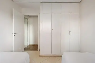 two white closets in a white room with two beds at TT Holidays-Rabat City Center in Rabat