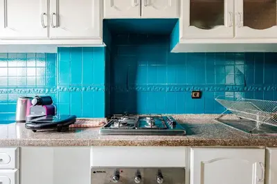 a blue tiled kitchen with a stove top at TT Holidays-Rabat City Center in Rabat