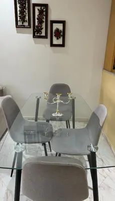 a glass dining room table with chairs and a cross on it at Coup de cœur a 5mn de l aéroport in Nouaceur