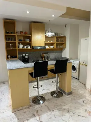 a kitchen with two bar stools at a counter at Coup de cœur a 5mn de l aéroport in Nouaceur