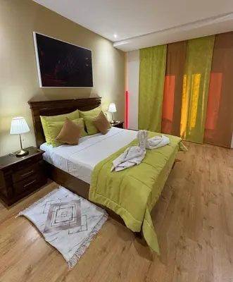a bedroom with a large bed with a green blanket at Coup de cœur a 5mn de l aéroport in Nouaceur