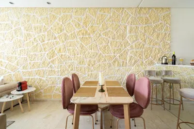 a dining room with a table and chairs and a stone wall at Paris-Oasis Casablanca in Casablanca