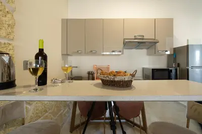 a kitchen with a counter with a bowl of bread and wine glasses at Paris-Oasis Casablanca in Casablanca