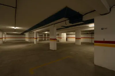 an empty parking lot with white columns in a parking garage at Paris-Oasis Casablanca in Casablanca
