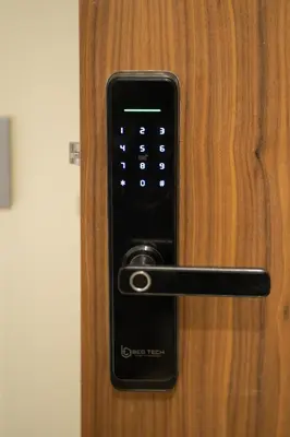 a black remote control on a wooden door at Paris-Oasis Casablanca in Casablanca