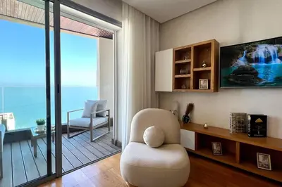 a living room with a chair and a view of the ocean at The Panorama of Marina - AppartAli in Casablanca