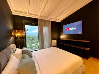 a bedroom with a bed and a flat screen tv at Golf view Villa with Jacuzzi- By AppartAli in Bouskoura