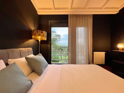 a bedroom with a large white bed with a window at Golf view Villa with Jacuzzi- By AppartAli in Bouskoura