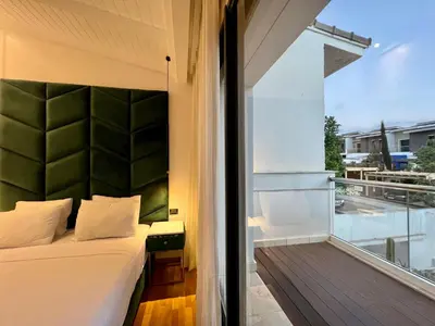 a bedroom with a bed and a view of a balcony at Golf view Villa with Jacuzzi- By AppartAli in Bouskoura