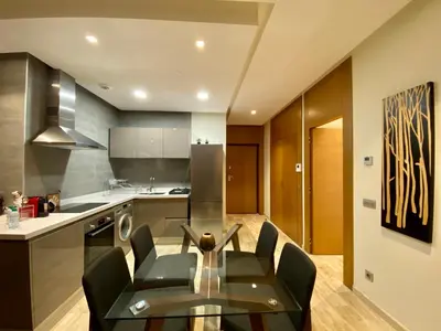 a kitchen with a glass table and black chairs at Faubourgs Anfa Top Floor By AppartAli in Casablanca