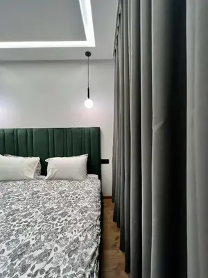 a bedroom with a bed with a green headboard and curtains at Anfa 212 Top Floor - 2 Bedrooms- By AppartAli in Casablanca