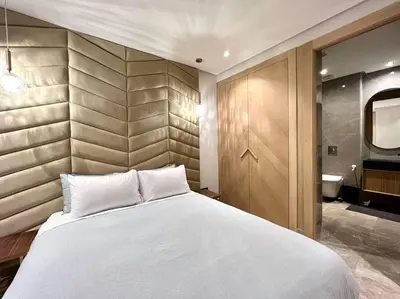 a bedroom with a large white bed and a bathroom at Centro 2 Bedrooms- By AppartAli in Casablanca