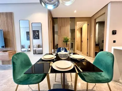 a dining room with a table and green chairs at Centro 2 Bedrooms- By AppartAli in Casablanca