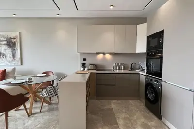 a kitchen with white cabinets and a table and a stove at Royal Suite by the Ocean - By Appartali in Casablanca