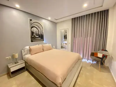 a bedroom with a large bed and a chair at Cosy Triangle D Or Bourgogne - By AppartAli in Casablanca