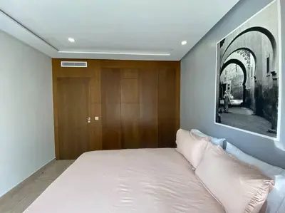 a bedroom with a large bed and a wooden wall at Cosy Triangle D Or Bourgogne - By AppartAli in Casablanca