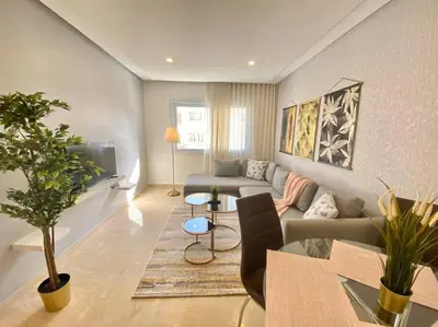 a living room with a couch and a tv at Cosy Triangle D Or Bourgogne - By AppartAli in Casablanca