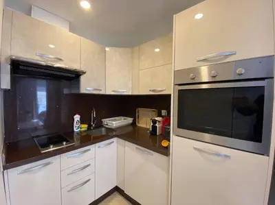a kitchen with white cabinets and a black microwave at Cosy Triangle D Or Bourgogne - By AppartAli in Casablanca