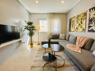 a living room with a couch and a flat screen tv at Cosy Triangle D Or Bourgogne - By AppartAli in Casablanca