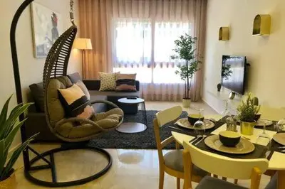a living room with a swing chair and a table at Triangle D Or Bourgogne - By AppartAli in Casablanca
