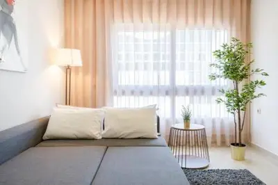a living room with a couch and a large window at Triangle D Or Bourgogne - By AppartAli in Casablanca