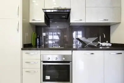 a kitchen with white cabinets and an oven at Triangle D Or Bourgogne - By AppartAli in Casablanca
