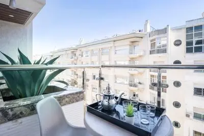a table on a balcony with a view of a building at Triangle D Or Bourgogne - By AppartAli in Casablanca