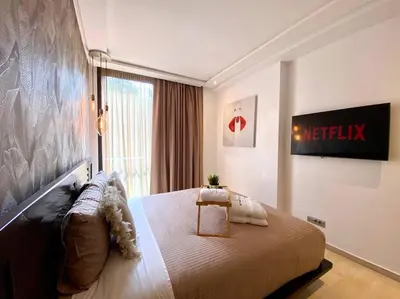 a bedroom with a large bed and a large window at La Corniche Garden View - By AppartAli in Casablanca
