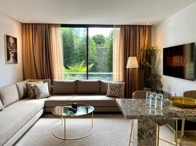 a living room with a couch and a large window at La Corniche Garden View - By AppartAli in Casablanca