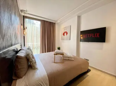 a bedroom with a large bed and a window at La Corniche Garden View - By AppartAli in Casablanca