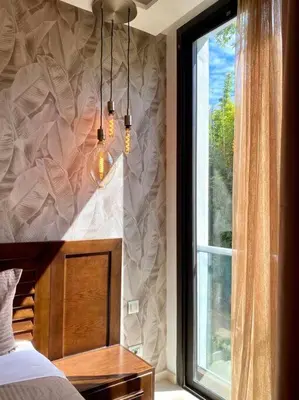 a bedroom with a window and a bed and a chandelier at La Corniche Garden View - By AppartAli in Casablanca