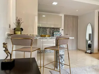 a kitchen with a counter and two chairs in a room at La Corniche Garden View - By AppartAli in Casablanca