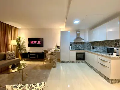 a kitchen and living room with a couch and a table at La Corniche Garden View - By AppartAli in Casablanca